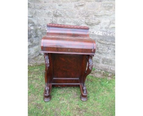 A 19th century rosewood piano top Davenport, having secret writing compartment and rising lid, opening to reveal drawers, pig