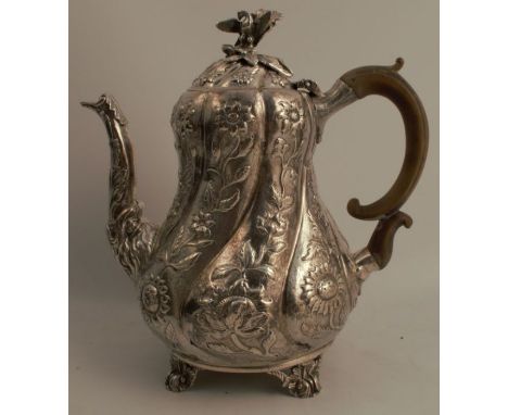 A Georgian&nbsp;silver coffee pot, the baluster shaped body decorated with flowers and leaves, with bird and leaf finial, rai