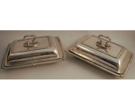 A pair of 19th century Paul Storr silver rectangular entrée dishes and covers, having gadrooned rims, engraved with armorials