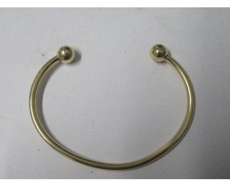 A plain torque bangle, stamped '9 KT' 12.5g gross