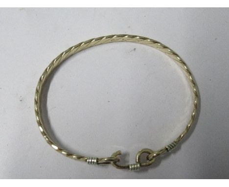 A 9 carat gold bangle, to a hook catch, inner diameter approximately 6.2cm, 18g gross
