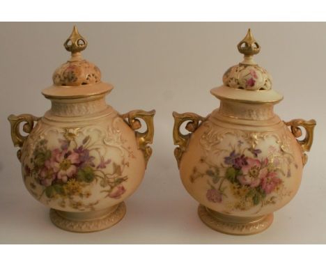 Two similar Royal Worcester blush ivory covered vases, with pierced covers, the body decorated with floral sprays, shape numb