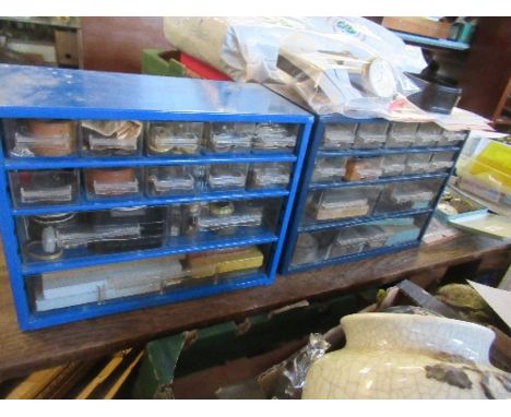 Two table top cabinets with drawers, containing a large quantity of watch making and repair accessories