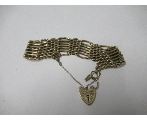 A yellow metal gate link bracelet, with a gold heart shaped lock, 26g gross
