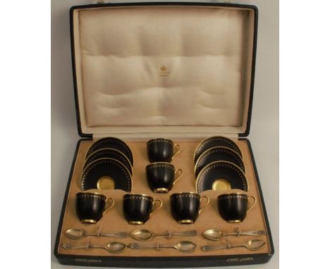 A cased set of six Royal Worcester coffee cups and saucers, in black and gold, with hallmarked silver coffee spoons, the box 