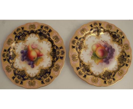 A pair of Royal Worcester plates, decorated with central panels of fruit, to a gilt blue gilded border by Shuck, diameter 9in