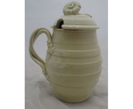 An 18th century Leeds creamware covered mustard pot, of barrel form with moulded body, with entwined ribbed strapwork handle 