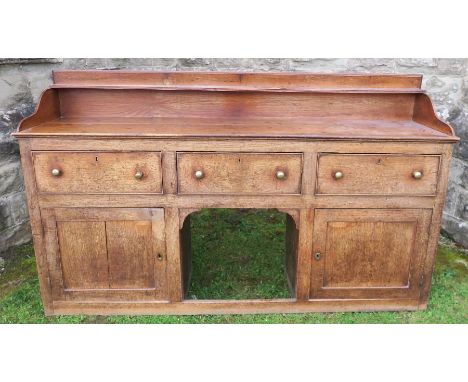 An antique oak Welsh sideboard, with three drawers to the frieze, above cupboard doors to each side, width 75ins x height 41.