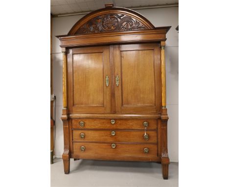 A two-door cabinet, Northern Netherlands, early 19th century. Oak wood, curved profiled hood with carving in motif of a vase 