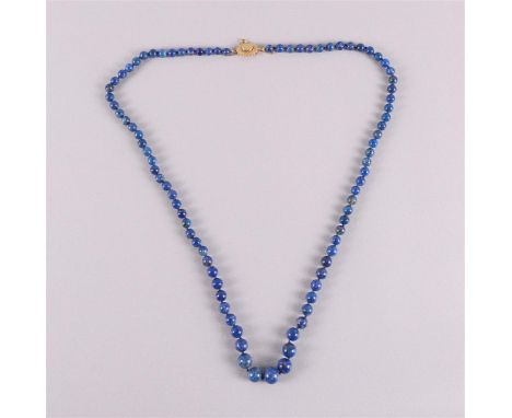 A necklace of lapis lazuli beads with a hammered 14 carat 585/1000 gold clasp and a safety chain. Length 85 cm.