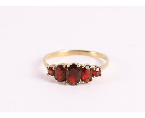 A 14 kt 585/1000 yellow gold row ring, set with faceted garnets, gross weight 1.4 grams, ring size 17 mm.