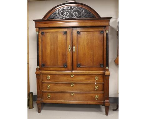 A two-door cabinet, Northern Netherlands, early 19th century. Oak wood, curved profiled hood with carving in motif of a vase 