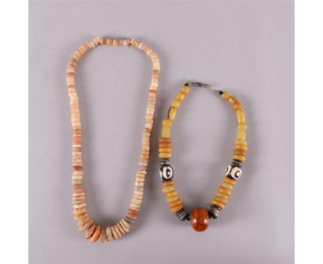 A necklace of beads, Neolithic, North Africa, length 70 cm. Hereby another necklace black / white and yellow beads, tot. 2x.