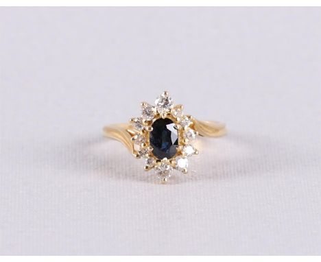 An 18 kt 750/1000 gold ring with an oval faceted blue sapphire and an entourage of 12 brilliants of 0.40 ct in total. Ring si