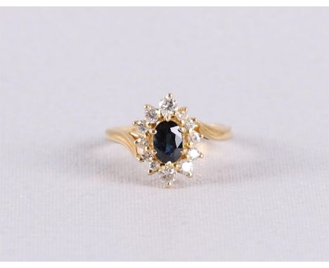 An 18 kt 750/1000 gold ring with an oval faceted blue sapphire and an entourage of 12 brilliants of 0.40 ct in total. Ring si