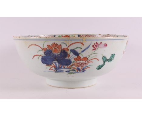 A Chinese Imari porcelain bowl on a stand ring, China, Qianlong, 18th century. Polychrome floral decor, h 11 x Ø 26 cm (glued