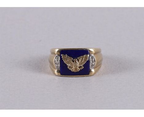 An 8 kt BWG ring with rectangular lapis flanked by 6 diamonds and decorated with an American Eagle. Ring size 18.5 mm.