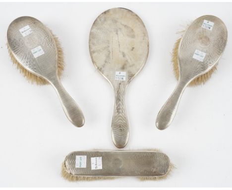A silver mounted four piece part dressing set, comprising; a hand mirror, a pair of hairbrushes and a clothes brush, all havi