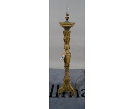 An 18th century giltwood altar candlestick (converted into a table lamp), carved foliate detail, distressed with old paint tr