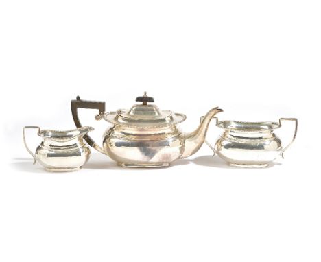 A silver three piece tea set, comprising; a teapot having black fittings, a twin handled sugar bowl and a milk jug, each piec