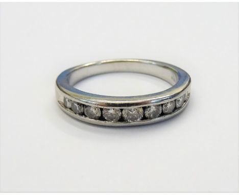 A platinum and diamond half hoop eternity ring, channel set with a row of nine circular cut diamonds, ring size K and a half,