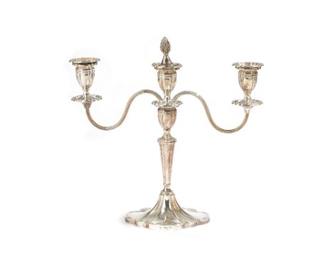 A silver three light table candelabra, the central stem raised on a shaped oval base, the detachable top section with reeded 