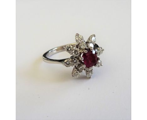 An 18ct white gold, ruby and diamond ring, in an eight pointed star shaped design, mounted with the square emerald cut ruby t