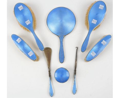 A lady's silver and blue enamelled part dressing set, comprising; a hand mirror, two hair brushes, two clothes brushes, a but