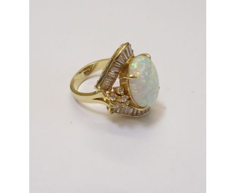 A gold, synthetic opal and colourless gem set ring, claw set with the oval cut synthetic opal to the centre, within a colourl