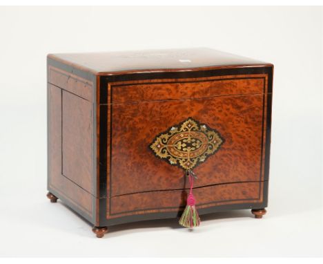 A 19th century brass and mother of pearl inlaid liqueur cabinet, the serpentine lift top and front revealing a four decanter 