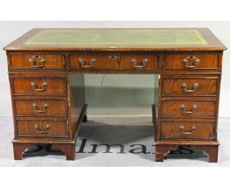 A 20th century hardwood pedestal desk with nine drawers about the knee, 138cm wide x 77cm high and a similar two drawer filin