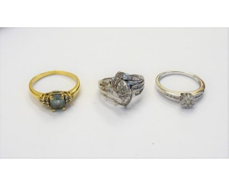 An 18ct gold ring, claw set with an oval cut aquamarine, between circular cut, diamond set three stone sides, a white gold an