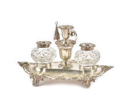 A Victorian silver twin bottle inkstand, of shaped oval form, decorated with scrolling border, raised on four feet, presentat