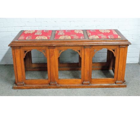 A 19th century Gothic Revival oak bench, with padded seat, over pierced arch base, 155cm wide x 66cm.