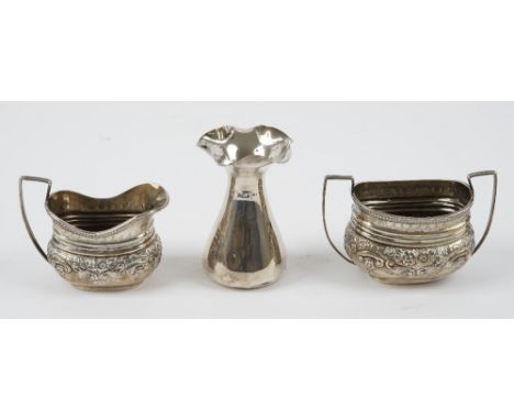 Silver, comprising; a milk jug and a matching twin handled sugar bowl, each with floral embossed decoration, London 1896 and 