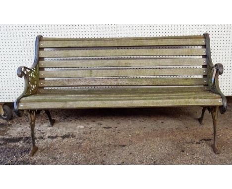 A late Victorian cast iron wooden slatted garden bench with scroll ends, 139cm wide x 78cm high. 