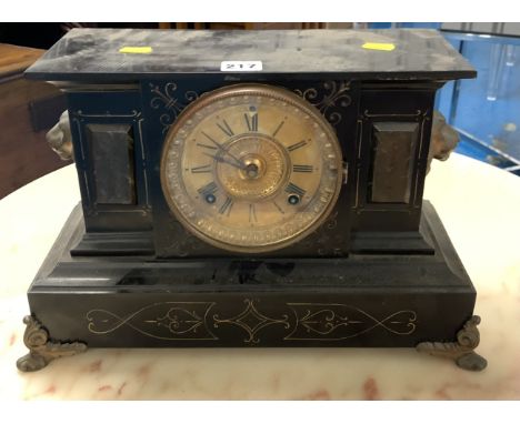 Black slate mantle clock with ormolu mounts with brass face and pendulum. 16” long x 10” high.