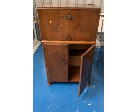 Walnut veneered cocktail cabinet with mirrored inside with lemon squeezer and cocktail sticks (1 missing) and cupboard below.