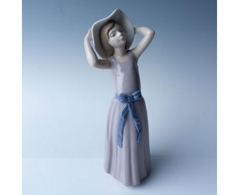 This Lladro porcelain figurine, titled "Coy" (01005011), stands 10.5"H and was made between 1979 and 1998. Designed by artist