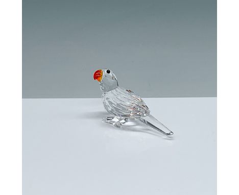 This Swarovski crystal parrot figurine, crafted in Austria, features precision-cut clear crystal with vibrant red and orange 