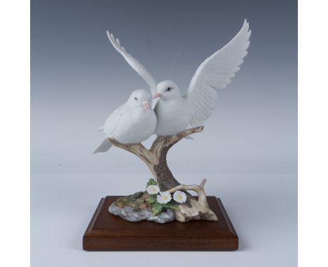 A Maruri USA Wings of Love fine porcelain figurine featuring two white doves perched on a branch, with intricate floral accen
