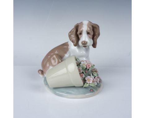 This Lladro porcelain figurine depicts an endearing puppy alongside an overturned flower pot filled with delicate pastel-colo