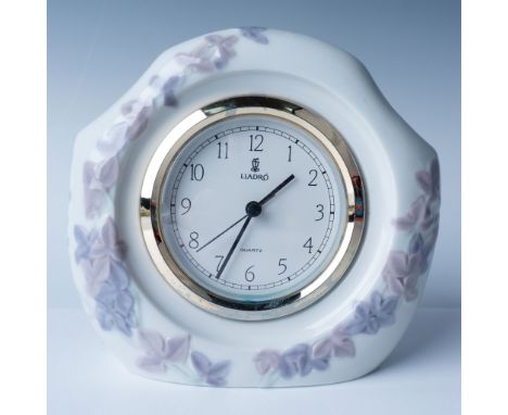 This elegant Lladro porcelain table clock, features a delicate floral motif in soft pastel tones, perfectly framing a quartz 