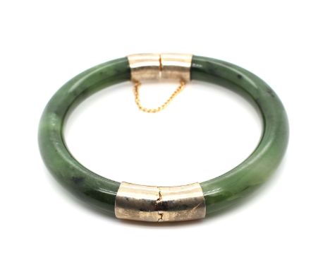 Armreif aus Jade (Nephrit) mit Metallmontierung.Gewicht: 45,6 g, Breite: 9,2 mm, Innenmaß: 62,5 - 59,3 mm. / Bangle made of j