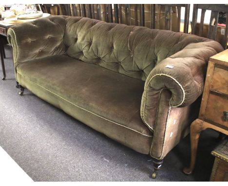 A 19th century Chesterfield sofa. With button back and arms, upholstered in a green fabric, raised on turned supports with me