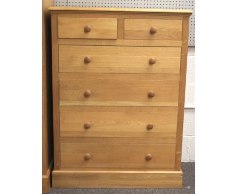 A contemporary light oak chest of drawers. With two short over four long drawers, turned handles and on a plinth base, L97cm 