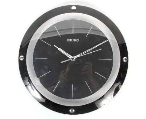 A vintage Seiko wall clock. The circular black dial with pierced white metal hands, within circular domed perspex and black r