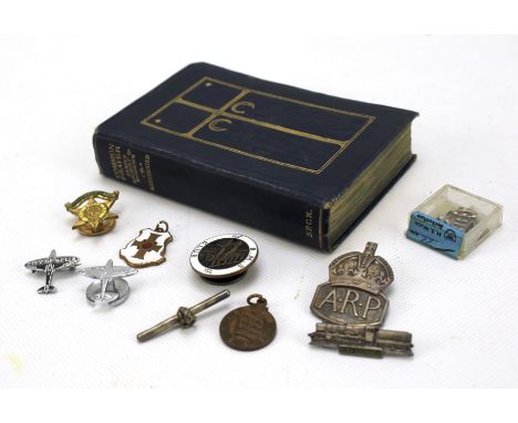 An assortment of collectables. Including a early 20th century prayer book, silver and enamel badges and a pair of cufflinks