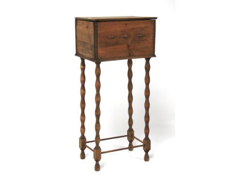 An early 20th century pine sewing box. The lid opening to reveal a fitted interior, raised on bobbin turned supports with str