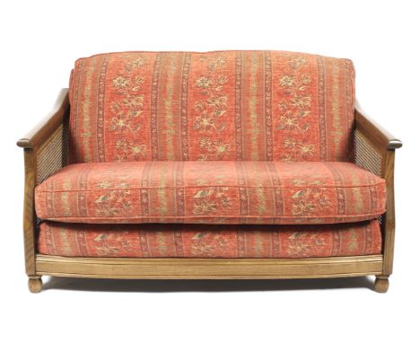An Ercol upholstered Golden Dawn bergere suite. With caned sides, comprising a three-seater sofa L187cm x D91cm x H91cm, a tw